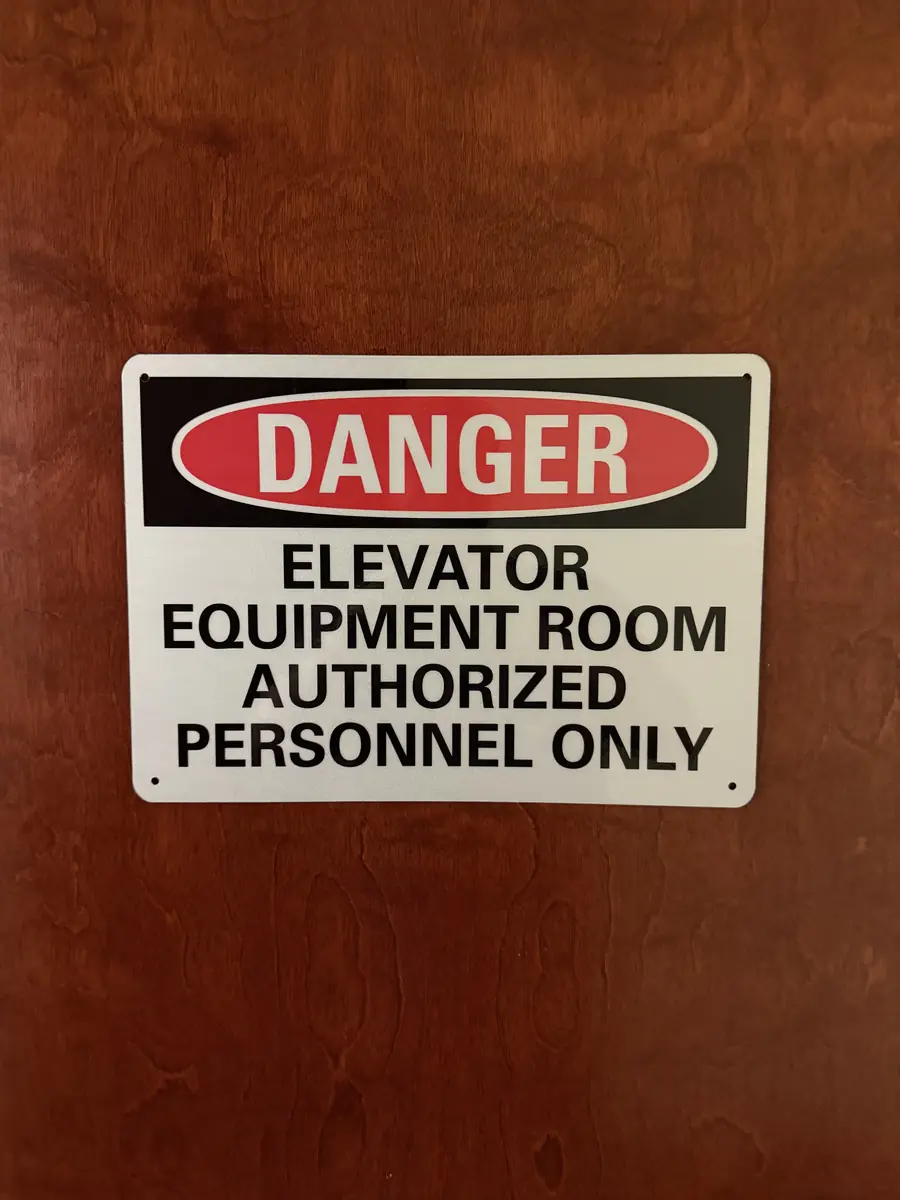 DANGER Elevator Equipment Room Authorized Personnel Only sign mounted on a wood door